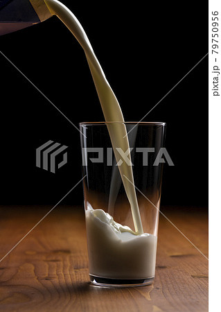 グラスに牛乳を注ぐ 79750956