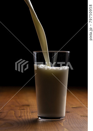 グラスに牛乳を注ぐ グラスに牛乳を注ぐ 79750958