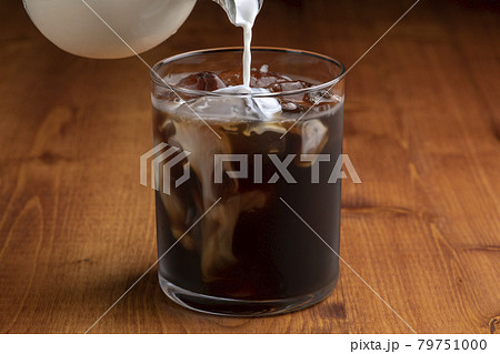 アイスコーヒーにミルクをいれるの写真素材