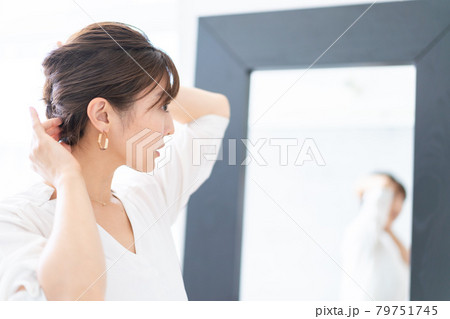 自宅でヘアスタイルを整える若い女性 79751745