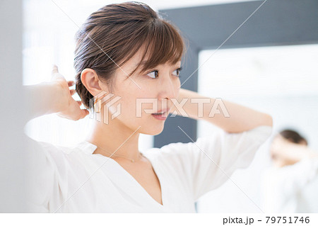 自宅でヘアスタイルを整える若い女性 自宅でヘアスタイルを整える若い女性 79751746