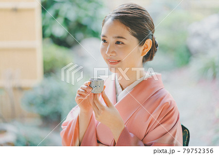 お猪口で日本酒を飲む着物姿の20代女性 79752356