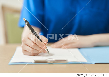 書類に記入する介護士の手元 79753819