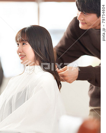 ヘアスタイリストに髪を切ってもらう女性客 ヘアスタイリストに髪を切ってもらう女性客 79754604