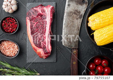 Raw beef meat Club or striploin on the bone steak with ingredients, on black stone background, top view flat lay Raw beef meat Club or striploin on the bone steak with ingredients, on black stone background, top view flat lay 79755107