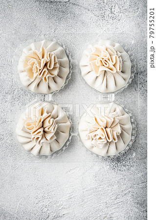 Uncooked Baozi chinese dumplings. Azian dumplings, in plastic tray, on gray stone background, top view flat lay, with copy space for text Uncooked Baozi chinese dumplings. Azian dumplings, in plastic tray, on gray stone background, top view flat lay, with copy space for text 79755201