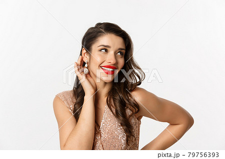 Concept of New Year celebration and winter holidays. Close up of beautiful woman dressed for party, blushing and smiling satisfied, showing her makeup, white background 79756393