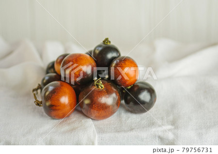 Tomatoes Indigo rose on a white surface. Tomatoes Indigo rose on a white surface. 79756731