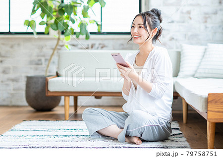 リビングでスマホを見る若い女性 リビングでスマホを見る若い女性 79758751