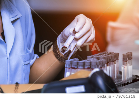 Doctor scanning data from the blood sample in the tube. Loading bar-code with laser scanner in hospital. Doctor scanning data from the blood sample in the tube. Loading bar-code with laser scanner in hospital. 79761319