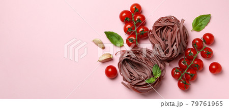 Uncooked pink pasta and ingredients on pink background Uncooked pink pasta and ingredients on pink background 79761965