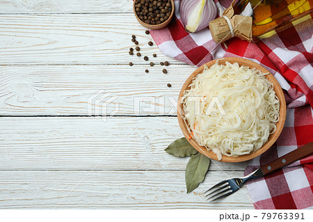 Fresh sauerkraut and ingredients on white wooden background Fresh sauerkraut and ingredients on white wooden background 79763391
