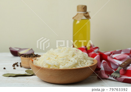 Fresh sauerkraut and ingredients on white wooden table Fresh sauerkraut and ingredients on white wooden table 79763392