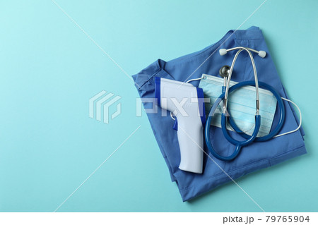 Medical tools and thermometer gun on blue background Medical tools and thermometer gun on blue background 79765904