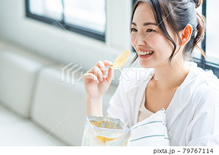ポテトチップスを食べる若い女性 ポテトチップスを食べる若い女性 79767114