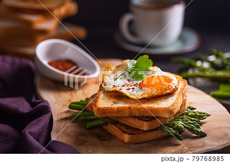 Fresh sandwiches with fried egg served with asparagus, pepper and parsley 79768985