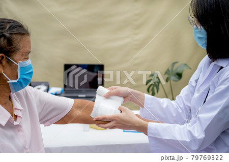 The doctor's is making a wound on the arm of an elderly woman who has an accident The doctor's is making a wound on the arm of an elderly woman who has an accident 79769322