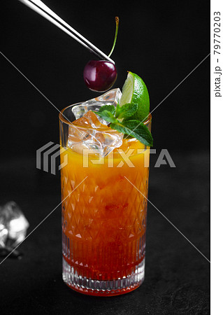 The chef decorates the drink with cherries with tweezers The chef decorates the drink with cherries with tweezers 79770203