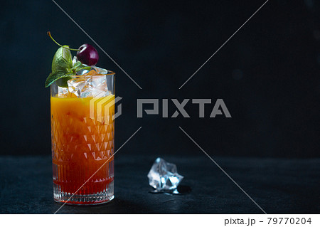 Cold juice with ice mint and cherries in a glass Cold juice with ice mint and cherries in a glass 79770204