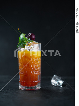 Orange juice with ice mint and cherries in a glass 79770205