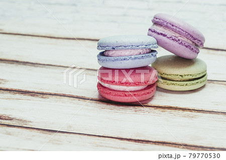 Multicolored macarons on a table and white wall background 79770530