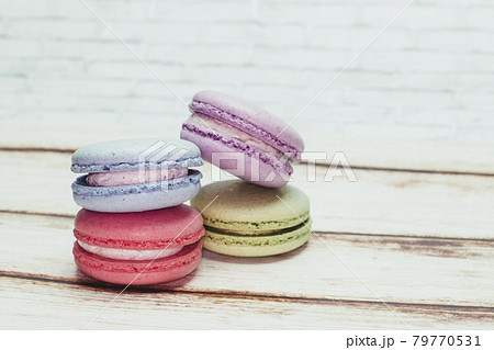 Multicolored macarons on a table and white wall background Multicolored macarons on a table and white wall background 79770531