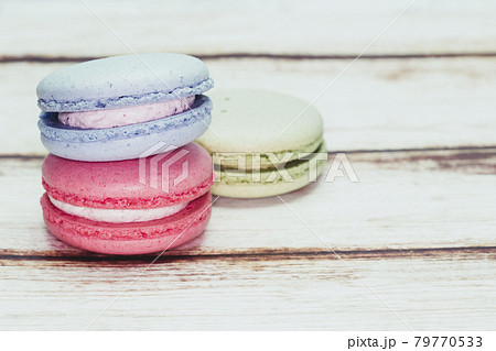 Multicolored macarons on a table and white wall background Multicolored macarons on a table and white wall background 79770533