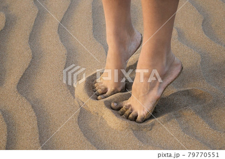 Detail of female legs on golden sea sand of the beach close up 79770551