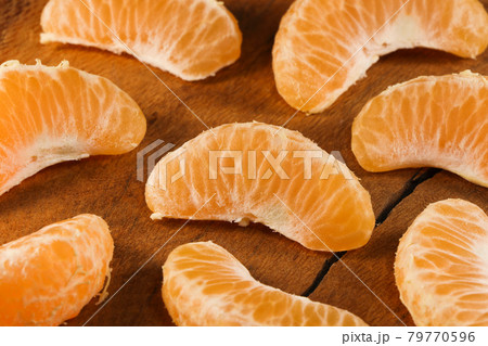 Satsuma Mandarin Tangerine Fruit Wedges On Natural Wood (Citrus unshiu) Satsuma Mandarin Tangerine Fruit Wedges On Natural Wood (Citrus unshiu) 79770596