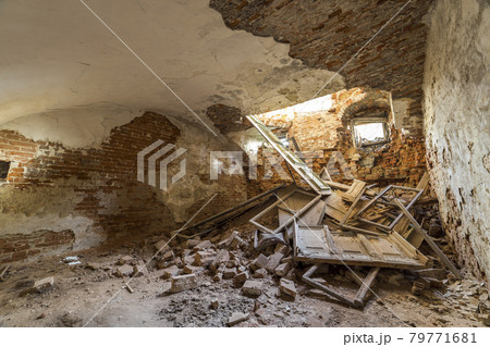 Old forsaken empty basement room of ancient building or palace with cracked plastered brick walls, low ceiling, small windows with and rubbish on dirty floor. Old forsaken empty basement room of ancient building or palace with cracked plastered brick walls, low ceiling, small windows with and rubbish on dirty floor. 79771681
