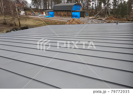 Close-up detail of house roof made from gray metal sheets. 79772035