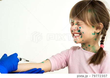 Doctor making vaccination injection to an afraid child girl sick with chickenpox, measles or rubella virus. Vaccination of children at school concept. 79772307