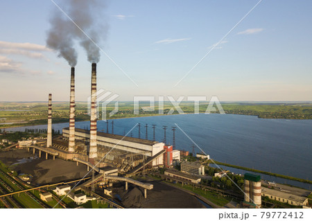 Aerial view of coal power plant high pipes with black smoke moving up polluting atmosphere. 79772412