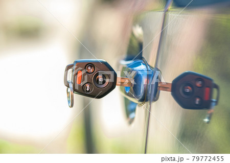 Close up of car door with key sticking out of the lock. Concept of process opening or closing vehicle. 79772455