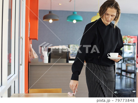 Coffee shop owner man cleaning on table at cafe. 79773848