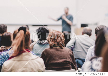 Man giving presentation in lecture hall at university. Man giving presentation in lecture hall at university. 79774113