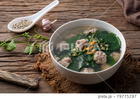 Ivy gourd soup with minced pork in white bowl on wooden table, Thai food. Ivy gourd soup with minced pork in white bowl on wooden table, Thai food. 79775297