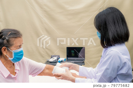 The doctor's is making a wound on the arm of an elderly woman who has an accident The doctor's is making a wound on the arm of an elderly woman who has an accident 79775682