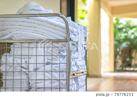 hotel maid trolley parking front of the room with clean towel and bathrobes ready to change and make up the room. 79776253