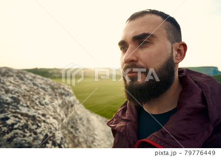 Young bearded man portrait outdoors in the mountains 79776449