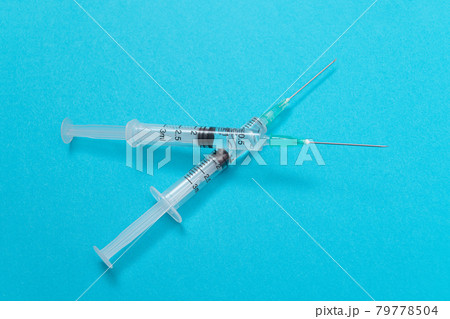 Vaccination or Revaccination Concept - Two Medical Syringe on Blue Table Vaccination or Revaccination Concept - Two Medical Syringe on Blue Table 79778504