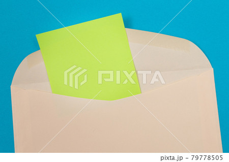 Beige Envelope with Blank Green Sheet of Paper Inside Beige Envelope with Blank Green Sheet of Paper Inside 79778505