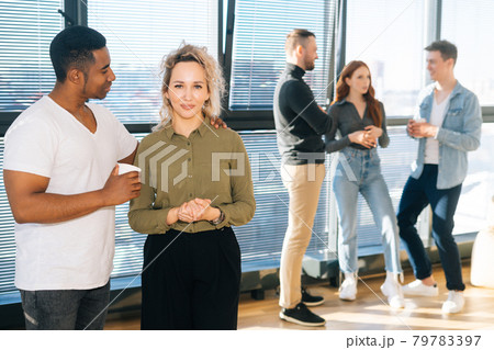 Portrait of African American male posing with young woman colleague looking at camera, selective focus. Portrait of African American male posing with young woman colleague looking at camera, selective focus. 79783397