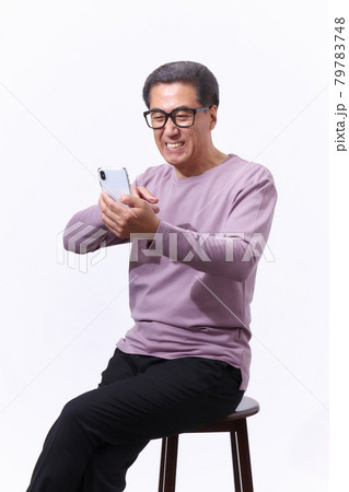 スマホを見る眼鏡のシニア男性 スマホを見る眼鏡のシニア男性 79783748
