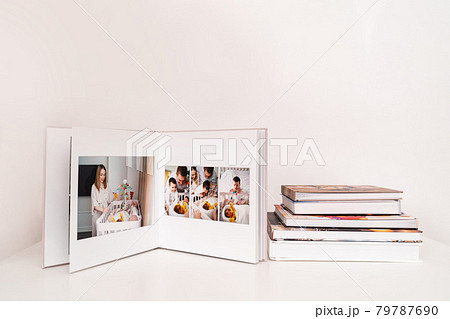 on white table open photobook from photo shoot of family with newborn. 79787690