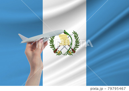 Airplane in hand with national flag of Guatemala. Travel to Guatemala Airplane in hand with national flag of Guatemala. Travel to Guatemala 79795467