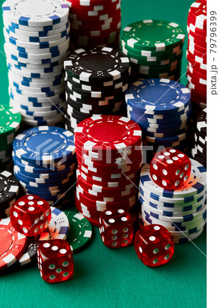 Pile of Casino pocker gambling chips and dices on green table 79796399