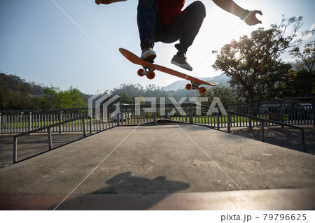 Young skateboarder legs skateboarding at skatepark 79796625