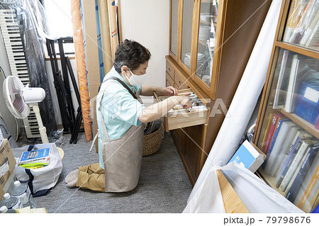 散らかった部屋の整理をする女性作業員 散らかった部屋の整理をする女性作業員 79798676