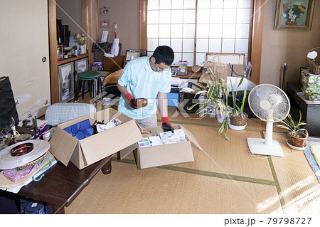 散らかった部屋の整理をする男性作業員 散らかった部屋の整理をする男性作業員 79798727